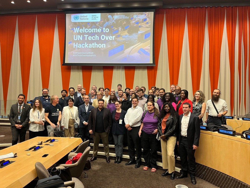 A large group of open source maintainers and technologists posing together at the UN Tech Over Hackathon during UN Open Source Week. Leah Wasser stands on the right side of the group.